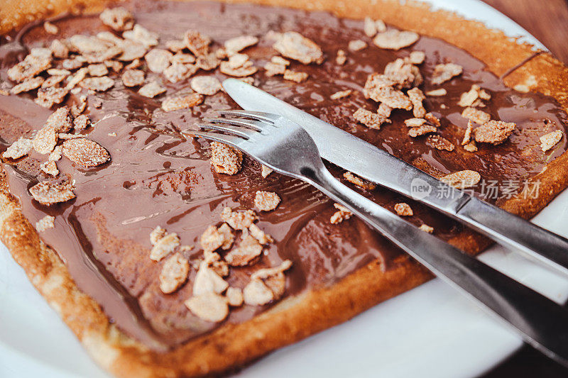 Sweet crêpe with hazelnut cocoa spread and sugar-frosted flakes served in Annecy, Haute-Savoie